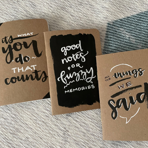 Three kraft pocket notebooks with watercolor lettering